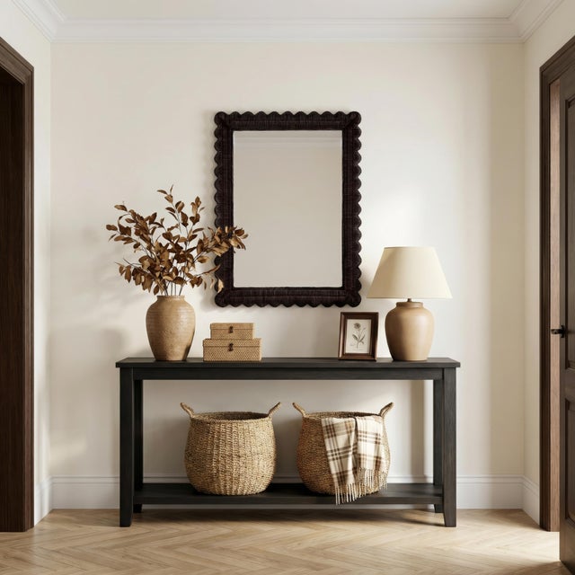 The Butler Specialty Company Flora Wall Mirror exudes casual elegance with its handwoven rattan frame and scalloped edges...