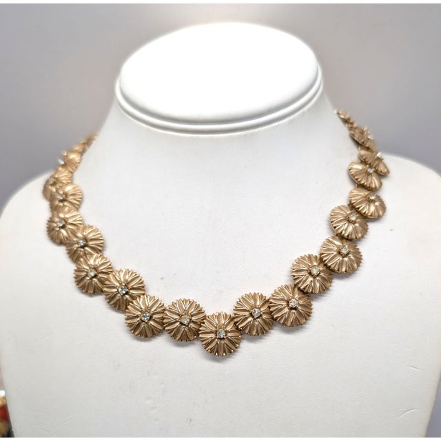 Mid to late 1950s goldtone "bursts" with single clear rhinestone center link necklace with hook clasp. Marked "TRIFARI©"...
