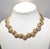 Mid to late 1950s goldtone "bursts" with single clear rhinestone center link necklace with hook clasp. Marked "TRIFARI©"...
