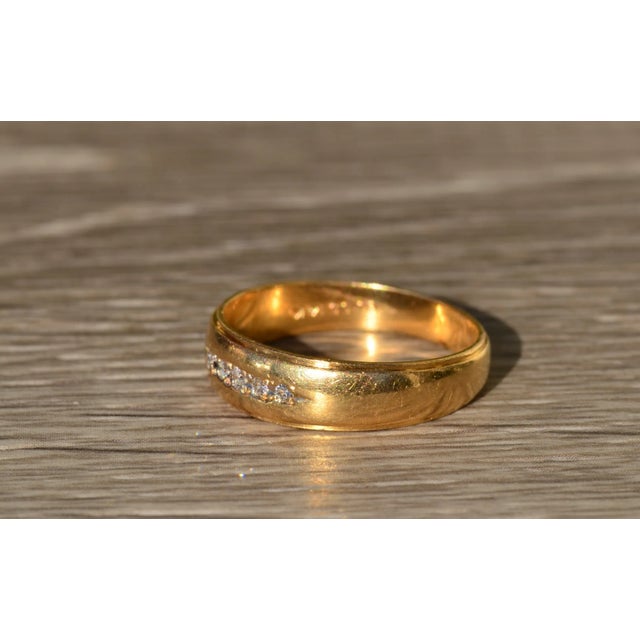 The Runestad Men's Vintage Engraved Yellow Gold and Diamond Wedding Band. Crafted in 14 karat yellow gold, this men's band...