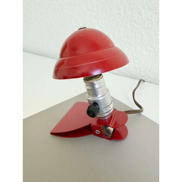 Vintage circa 1950s mini metal clip lamp that features a mushroom-shaped shade, vibrant red paint on an aluminum frame...