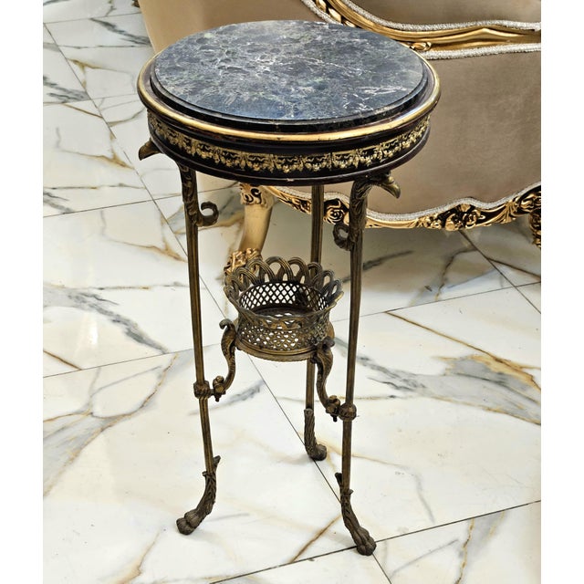 Discover a truly distinctive accent piece with this elegant side table, featuring a round dark marble top framed by a...