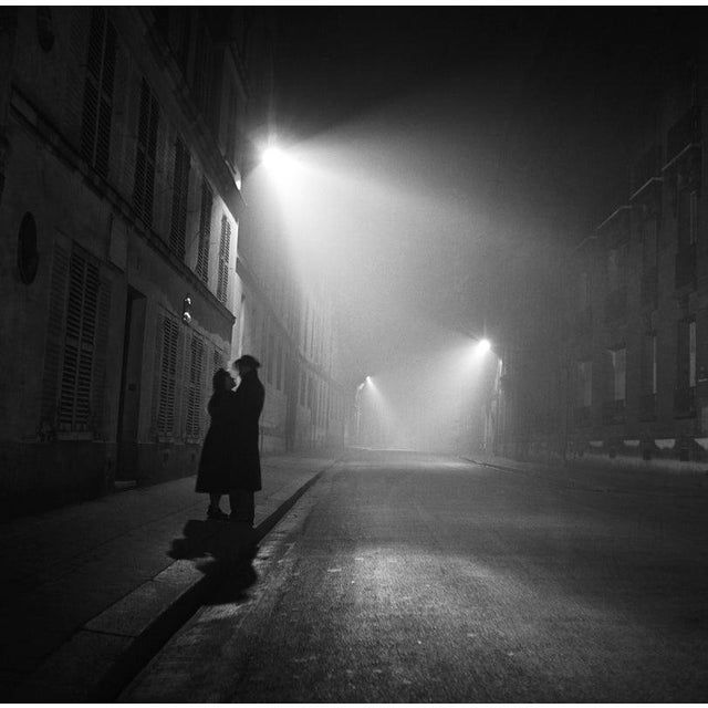 Paris At Night PARIS FRANCE - NOVEMBER 1: A couple embrace on a foggy street at night on November 1 1948 in Paris, France....