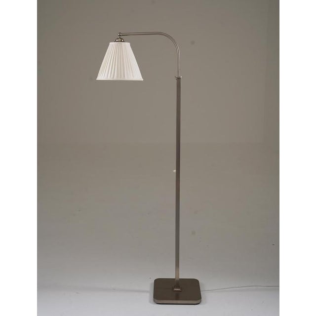 Elegant 1930s floor lamp made in Sweden, crafted from matte nickel-plated brass. Features a newly sewn, hand-pleated silk...