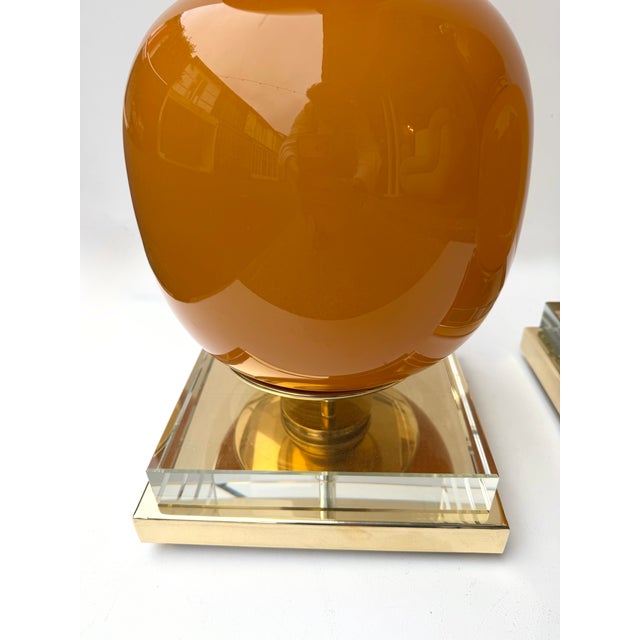 Pair of table or bedside bulb lamps in brass and orange Murano glass. Contemporary work from a small italian design...