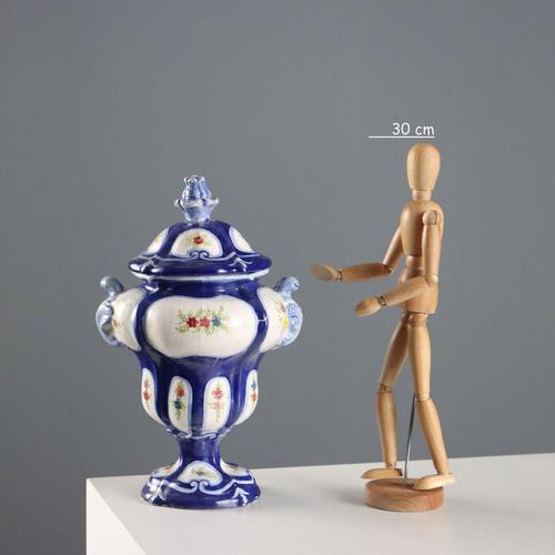 Ceramic pharmacy jar with a ribbed body and polychrome floral decorations. The manufacturer's mark is under the base. This...