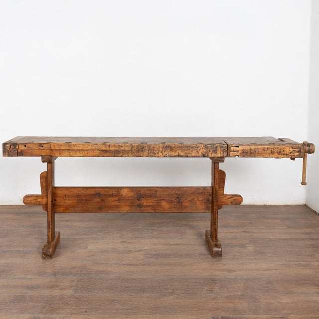 The worn patina of this old carpenter's workbench is a reflection of its age and years of use. Every ding, scratch, deep...