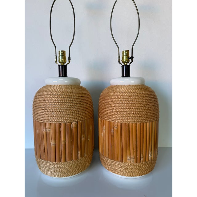 Beautiful pair of vintage 1970s coastal organic table lamps featuring ceramic bodies accented with natural bamboo and...