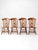 A set of four vintage dining chairs in the Early American taste, featuring turned spindle backs, shaped crest rails,...