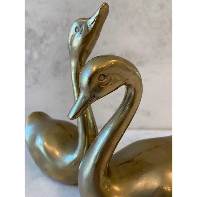 A pair of vintage mid century modern solid brass (heavy) "love" swans. Swans have a nice patina. Small swan measures - 5"w...
