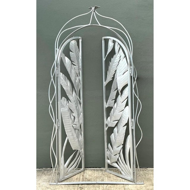This pair of gates transforms structural ironwork into a dramatic botanical statement, with an arched frame enclosing a...