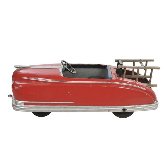 Red car for children with metal pedals. This piece is designed in the style of the selected designer and/or manufacturer