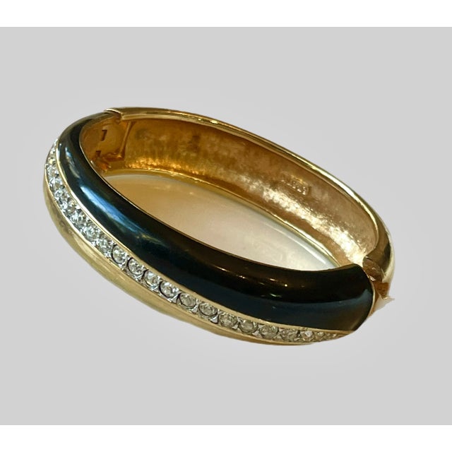 Vintage cuff with a swath of black enamel, accented by sparkly crystals mounted on gold plate. Signed DSC, Daniel...