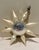 Rare German Sputnik mercury glass ornament in white and silver with colored accents. Eight white star arms feature gold,...