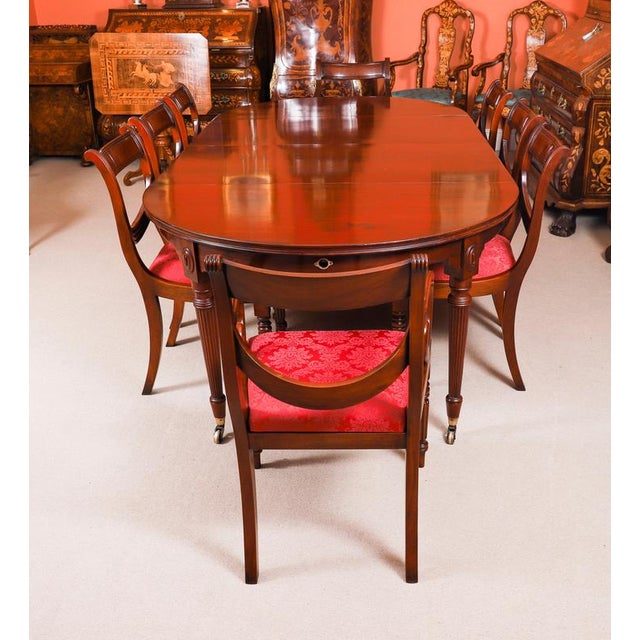 This is an elegant antique dining set comprising a regency revival flame mahogany wind-out telescoping-movement dining...