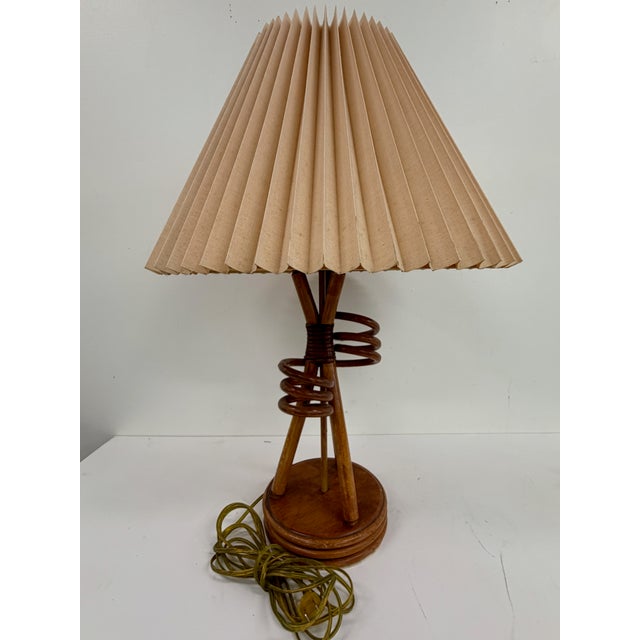 Mid-Century Modern table lamp with sculptural wood base featuring wrapped spiral detail and tapered tripod supports....