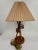 Mid-Century Modern table lamp with sculptural wood base featuring wrapped spiral detail and tapered tripod supports....