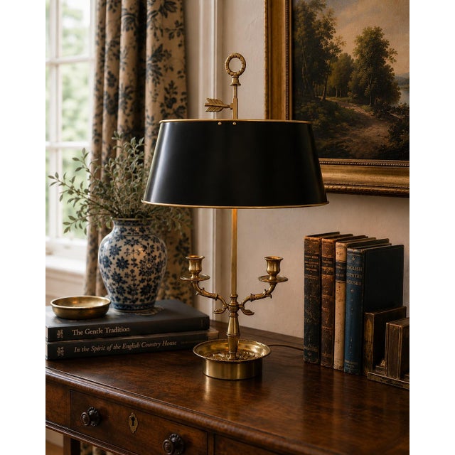 A classic bouillotte lamp rendered in warm brass, distinguished by its sculptural double dolphin motif and clean, tailored...
