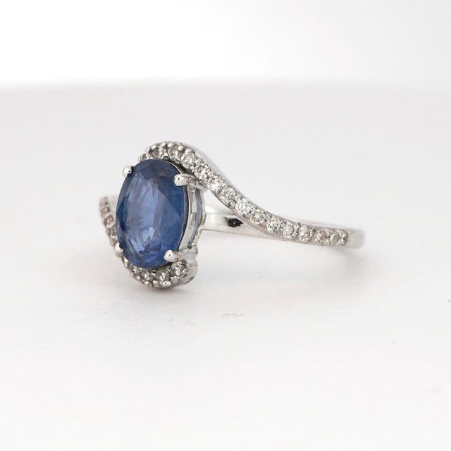 A harmonious blend of elegance and brilliance. This striking ring showcases a captivating 1.34 carat oval-cut blue...