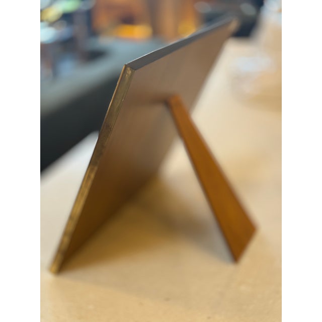 A refined brass photo holder designed to display images with ease and flexibility. The rectangular panel features a warm,...