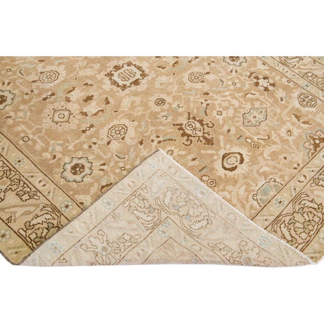 A beautiful Antique Malayer hand-knotted wool rug with a beige color field. This rug has blue and brown accents in an all-...