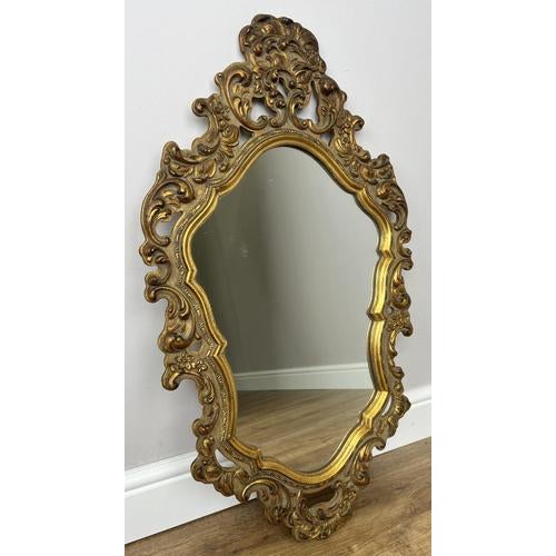 A stunning Vintage French mirror featuring an exquisitely ornate decorative frame with rich detailing and elegant curves....