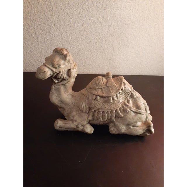 This is a Textured Stoneware 7" Sitting Camel Figurine. Procured at auction BOX B