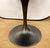 Williams Sonoma round tulip table with a black stone top and sculptural metal pedestal base with a bronze finish. A sleek,...