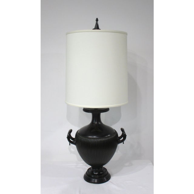 A very well crafted darken bronze table lamp with incised designs to the upper neck area and ribbed body having unique...