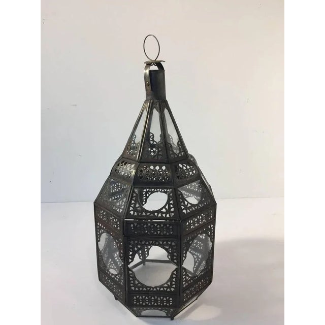 Moroccan Moorish clear glass lantern with intricate metal filigree. Octagonal shape, delicately handcrafted by artisans in...