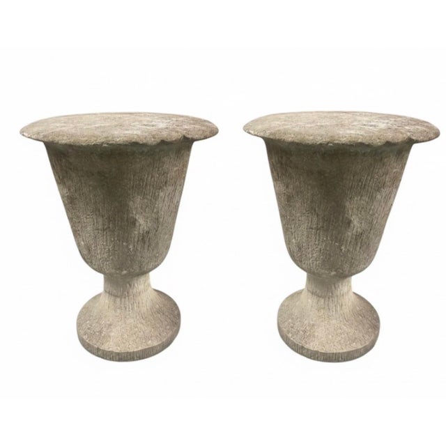 A compelling pair of mid-to-late 20th-century brutalist-style urns, masterfully crafted from cast stone with a heavy,...