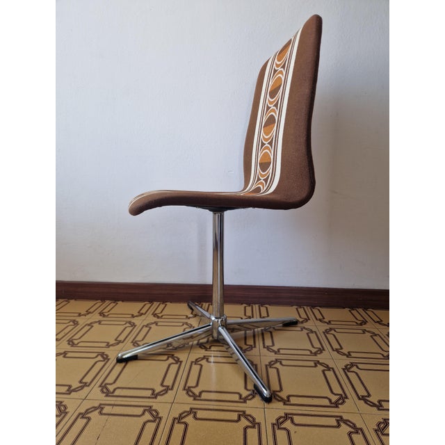 A refined swivel chair dating back to the 1970s, featuring an unmistakable Space Age/Mid-Century Modern design. The...