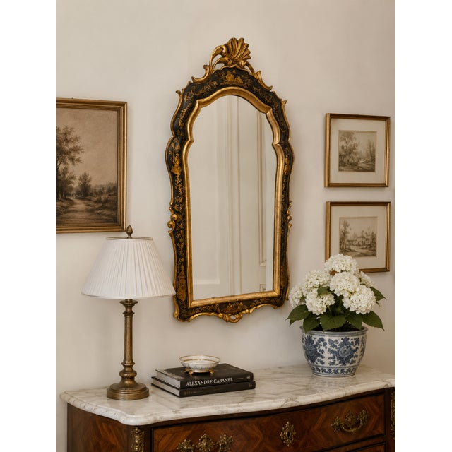 A striking vintage Venetian-style wall mirror featuring an elegantly shaped Rococo-inspired silhouette with richly...