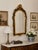 A striking vintage Venetian-style wall mirror featuring an elegantly shaped Rococo-inspired silhouette with richly...