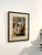 Matted and framed relief print of a portrait of a woman, with a pattern reminiscent of wood grain. Signed.