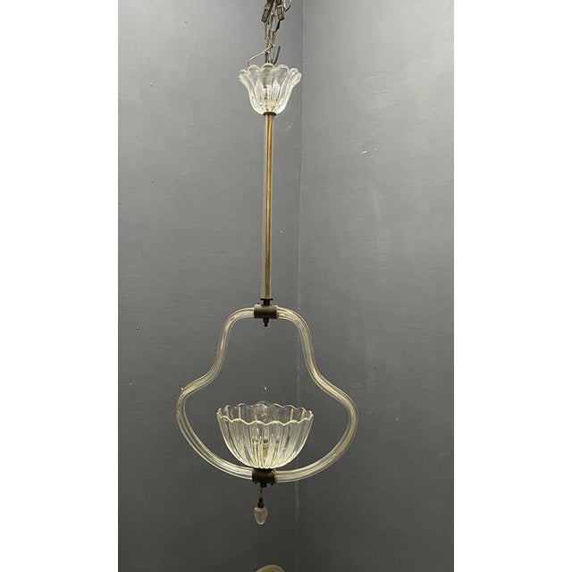 Refined 1950s pendant light attributed to barovier, crafted in murano glass and brass. The elegant composition features a...