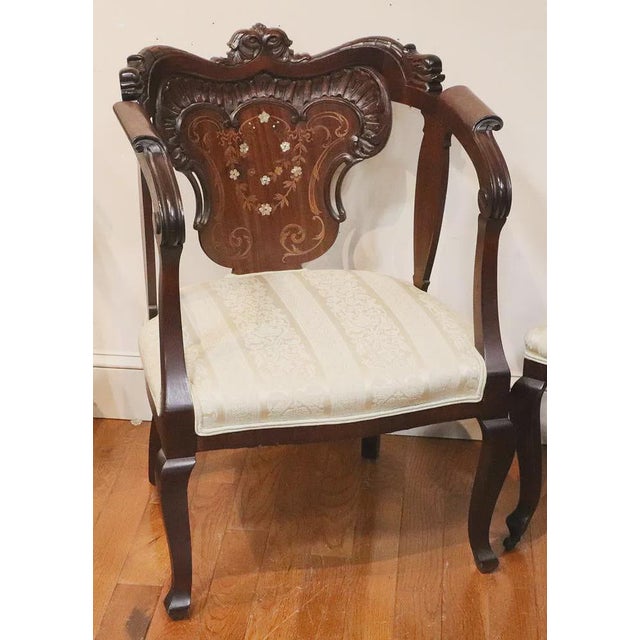 This French Style Antique Mahogany Armchair is a fully assembled piece with a rich brown color and intricate mother of...