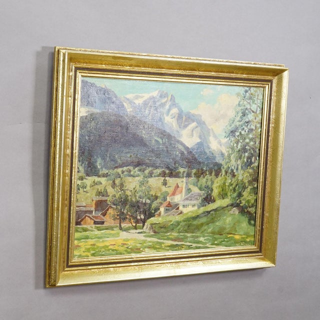 Alpine Landscape Oil Painting with Tyrolean Mountain Village A large landscape painting, framed in a gold-colored frame....