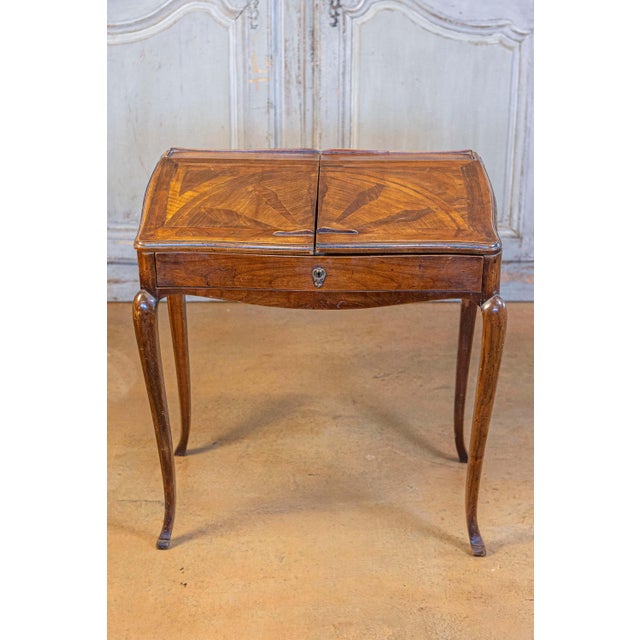A stamped French Louis XV style small walnut slant-front desk with sliding inlaid panels, long drawer and inner...