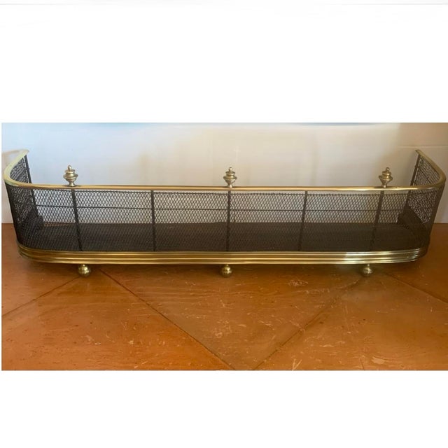 A classic English handwoven wirework fender with brass surrounds. The lower border is a wide brass moulding resting on...