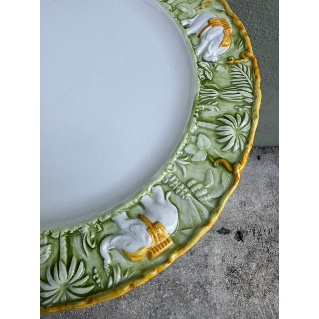 A stunning Italian ceramic charger featuring an exquisitely detailed relief border of white elephants with golden howdahs...