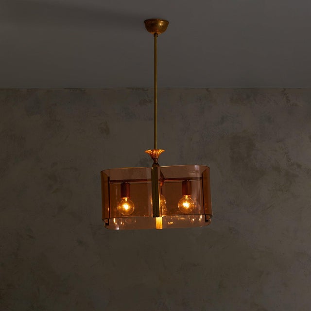 This expressive yet restrained pendant light from 1970s Italy is defined by a band of curved smoked glass encircling a...