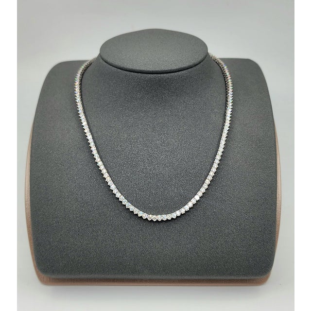 A modern platinum necklace adorned with 11.21 carats of natural round-cut white diamonds, exhibiting a clarity of VS2/SI1...
