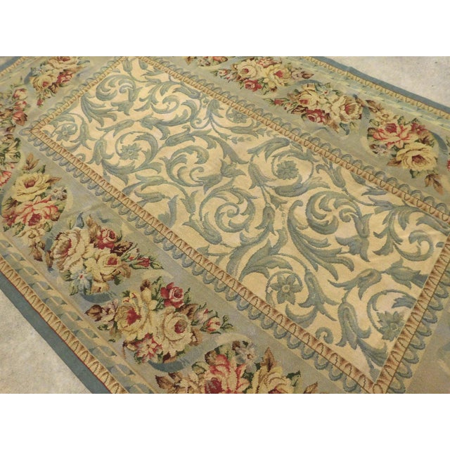 Handmade needlepoint in French style. Main field decorated with stylized foliage, within floral border. Flat woven with...