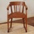 A semi-circular oak armchair, created around 1920–1930, reflecting the functional office and work furniture of the...