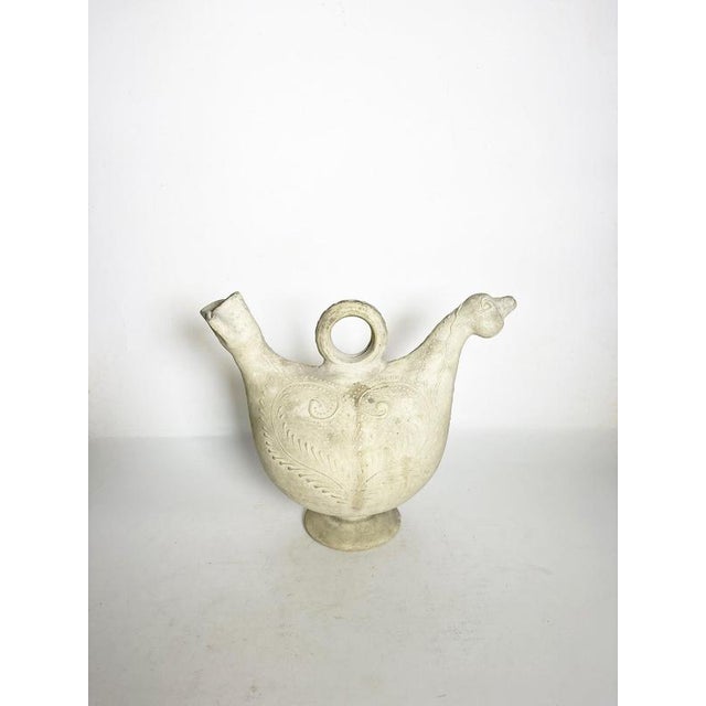Charming French decorative pitcher modeled in the stylized form of a hen or bird. Crafted in ceramic with a soft off-white...