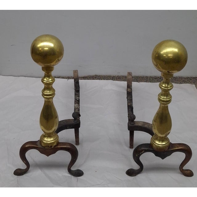 A Pair of late 19th Century Canon Ball Brass and Iron Andirons. It measures 8.5" in width 18.5" in depth, 18" in height.