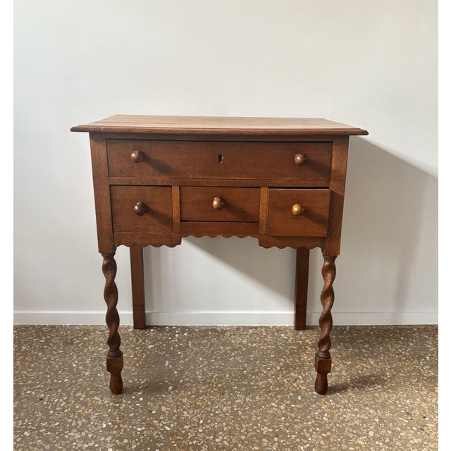 Beautiful oak side table with 4 drawers with nice round knobs. Striking because of its turned front legs and the curvy rim...