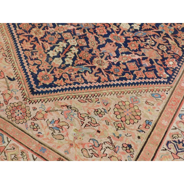 Antique hand knotted gallery carpet with an all-over repeating floral and Herati-style motif across a deep navy field and...