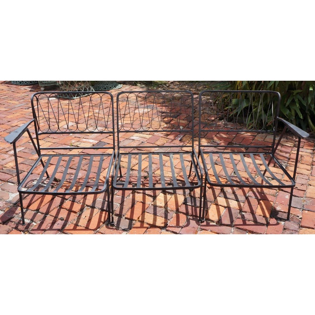 This vintage mid-century modern modular patio set features a black-painted wrought-iron loop-back design in the style of...